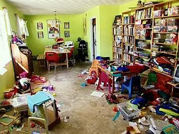 very messy room with lime green painted walls boks toys containers everywhere on carpeted floor