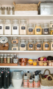 organized pantry 4 shelves with glass containers full of food and spices baskets cleaning supplies