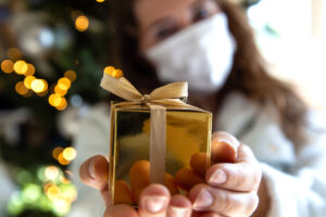 Person holding gold wrapped christmas gift