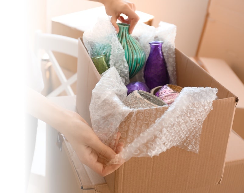 moving management banner with an image of a box full of glass vases and bubble wrap